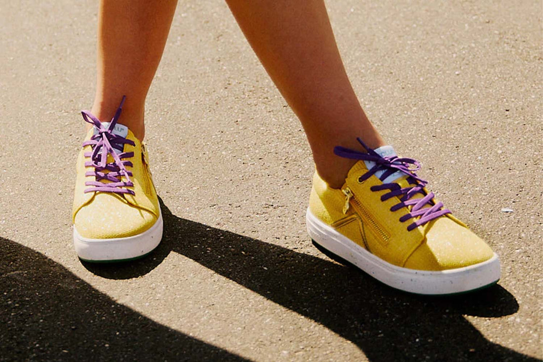 Woman wearing yellow and purple sneakers