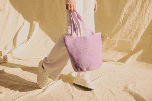 Woman holding a purple tote bag